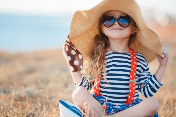 Pretty Little Girl In A Striped Dress And Hat Relaxing On The Beach Near Sea Summer Vacation Travel Concept